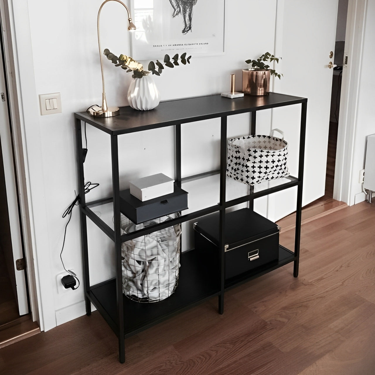 Modern industrial style shelving unit with a thin black metal frame and clear glass tiers.