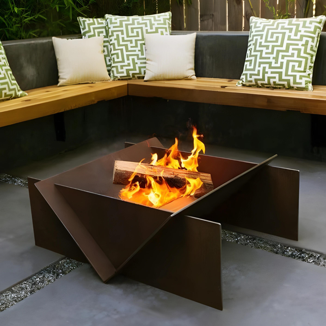 Contemporary brown metal fire pit with a geometric design and a burning fire inside, set on a patio.