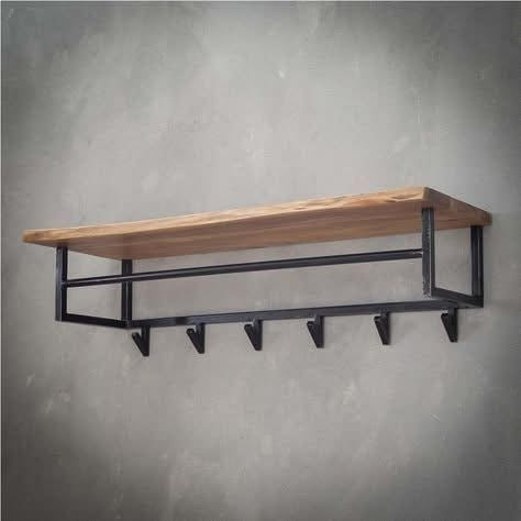 Wall-mounted coat rack featuring a thick, light-colored wooden shelf with a natural edge, resting on a minimalist black metal frame with a hanging rod and six triangular hooks