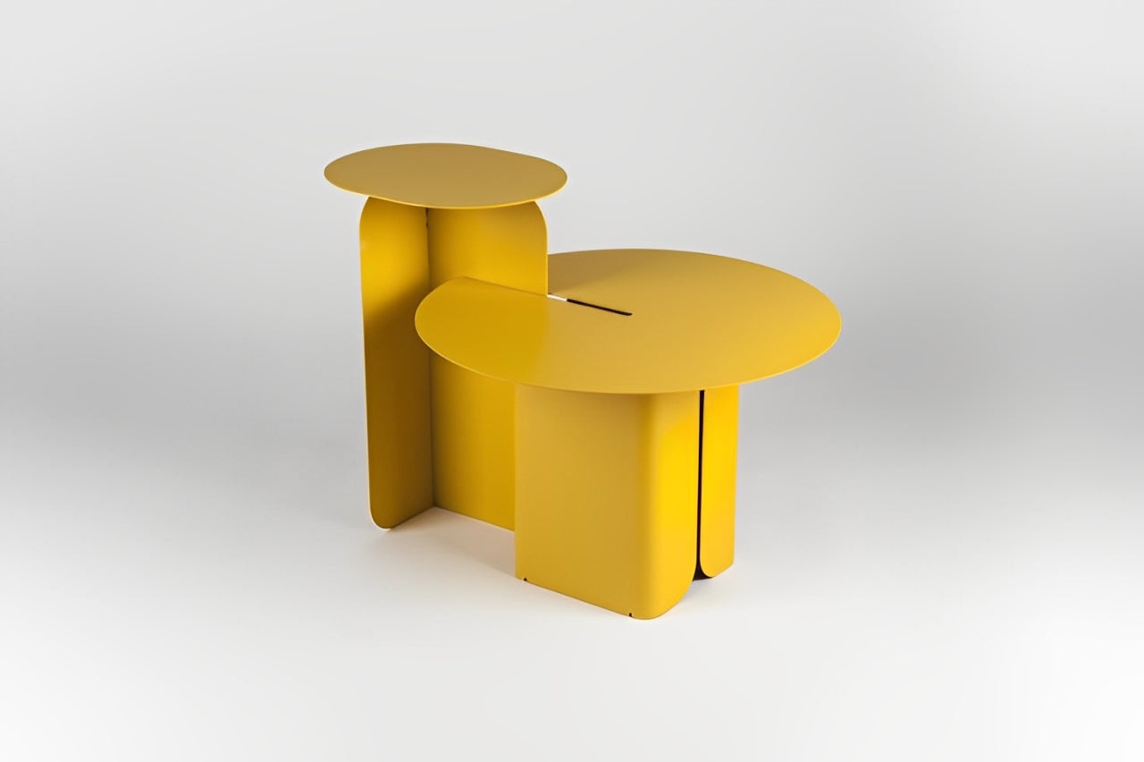Modern gray round side table with tiered design, gold geometric sculpture, and book.