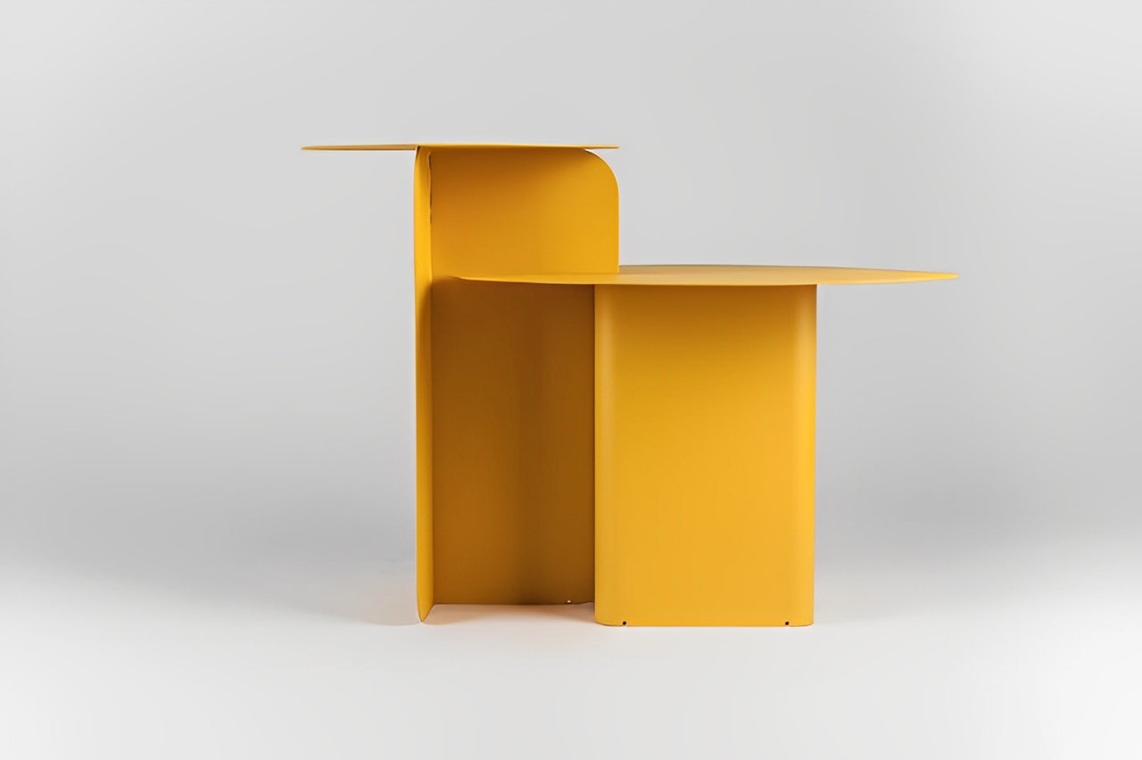 Modern gray round side table with tiered design, gold geometric sculpture, and book.