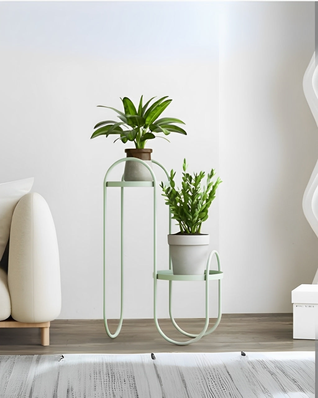 Modern black metal plant shelf with a thin, curved frame. The shelf has two tiers: a small round shelf on the right and a taller rectangular shelf on the left.