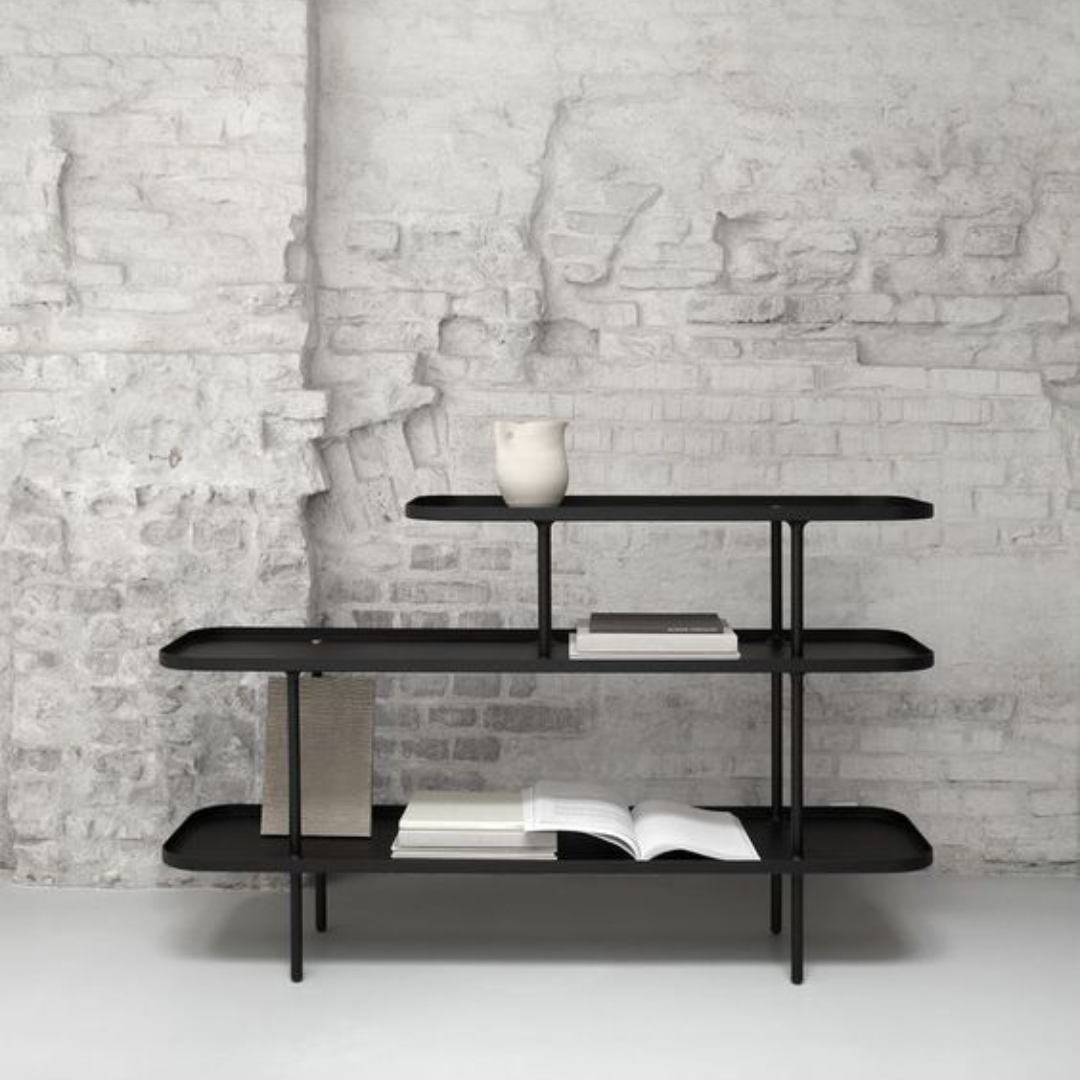 Mini Montana Console, three-tiered shelf with rounded edges, displaying books and a white vase against a brick wall.