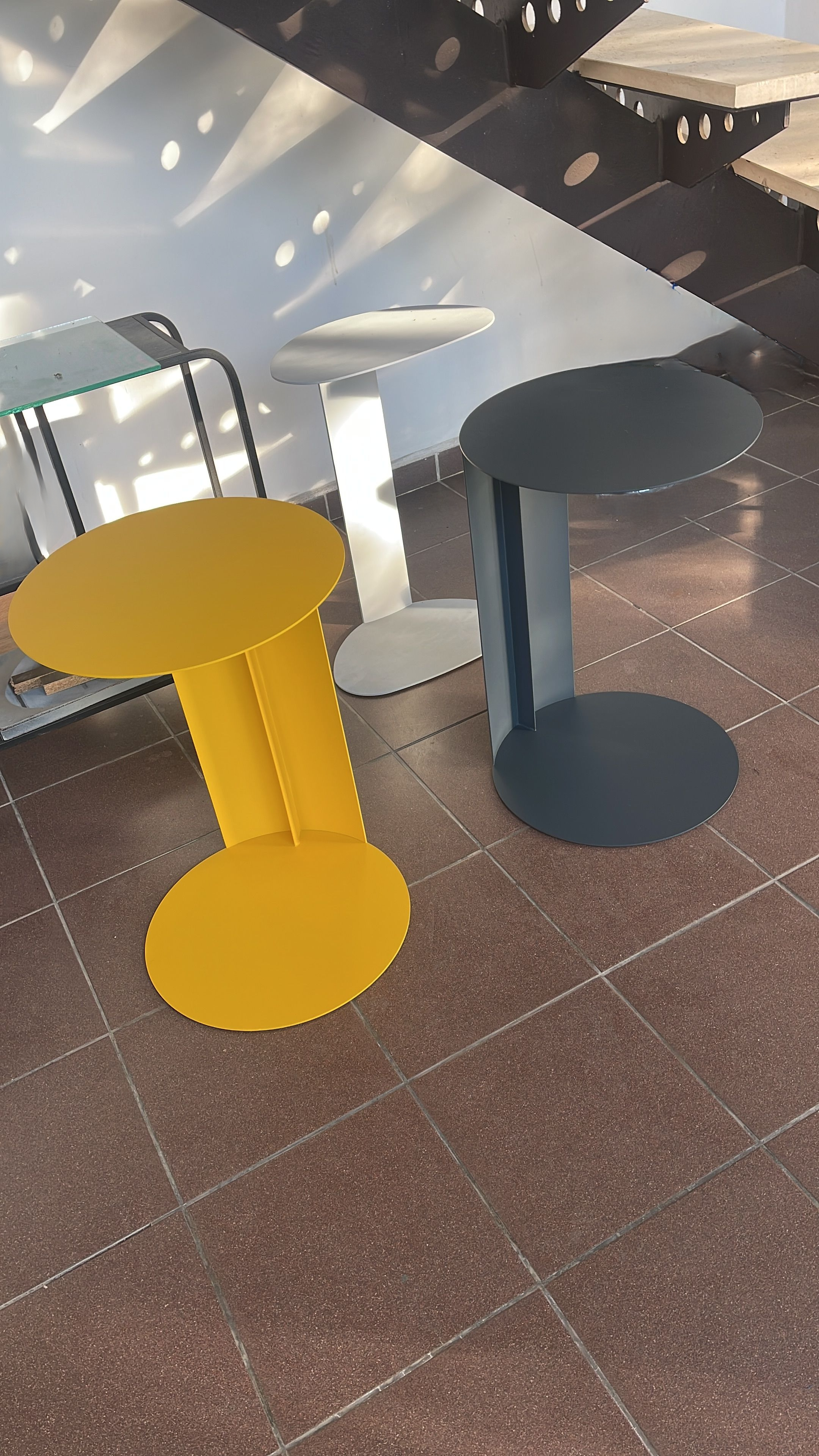 Minimalist dark grey C-shaped side table for sofa or chair.