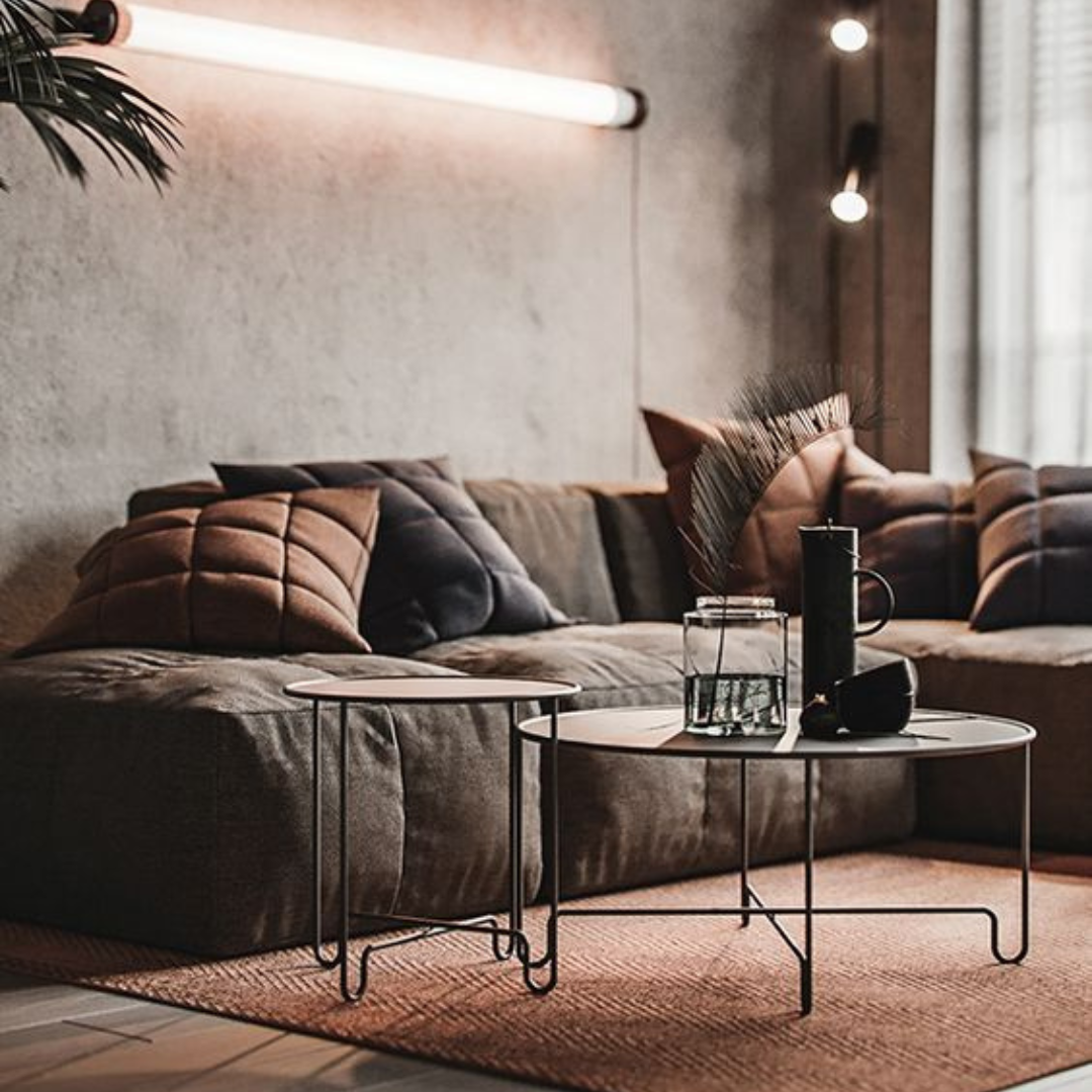 Modern nesting coffee tables with thin black frames and round tops, one slightly larger than the other.