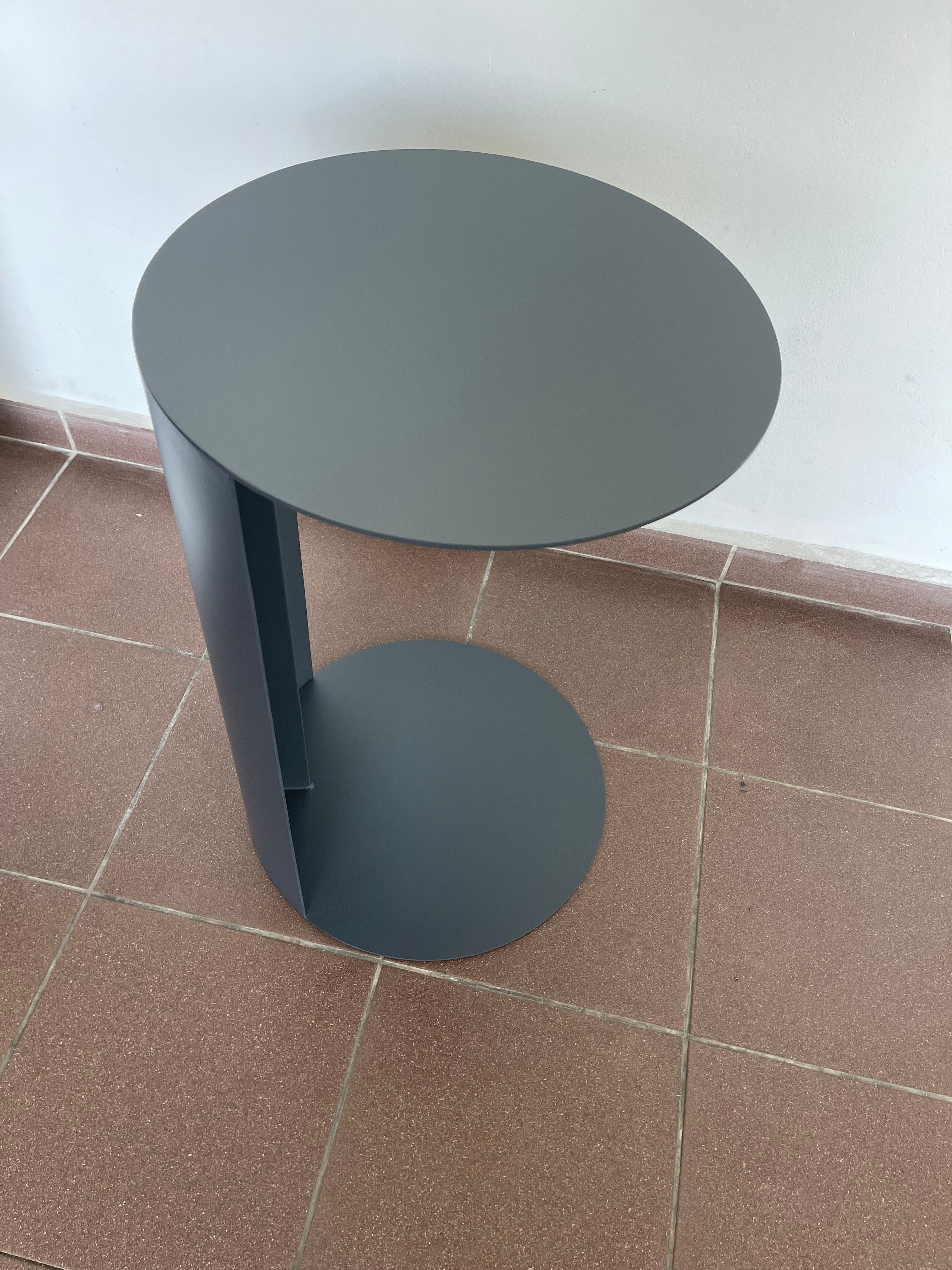 Minimalist dark grey C-shaped side table for sofa or chair.