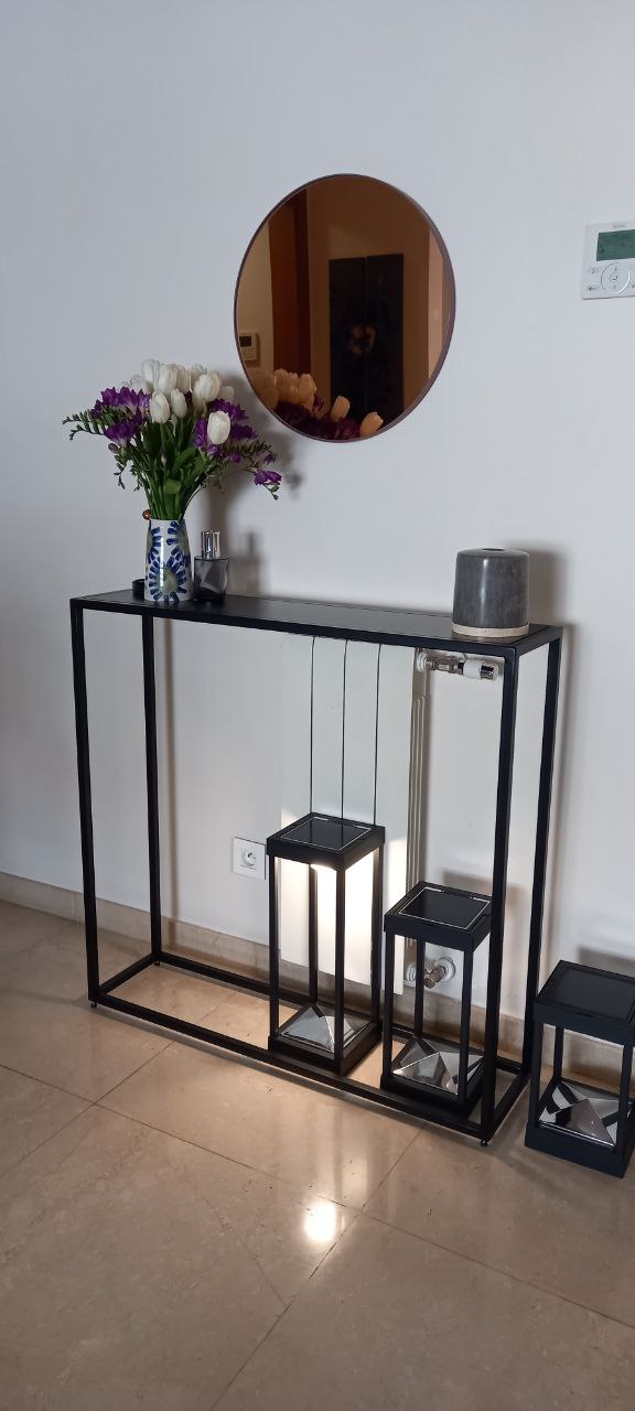 Modern black console table with nested side tables and decorative items.