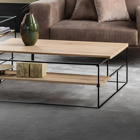 Rectangular coffee table with a light-toned wooden tabletop, a black metal base, and a matching lower shelf holding decorative items.