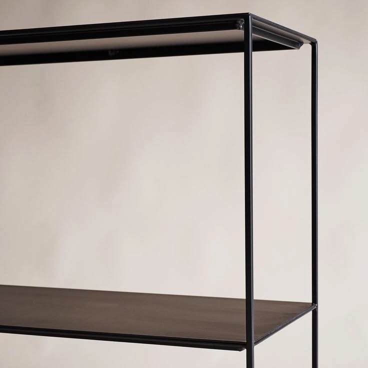 Slim Irony black two-shelf sideboard with a minimalist open frame design, displaying a vase and books.